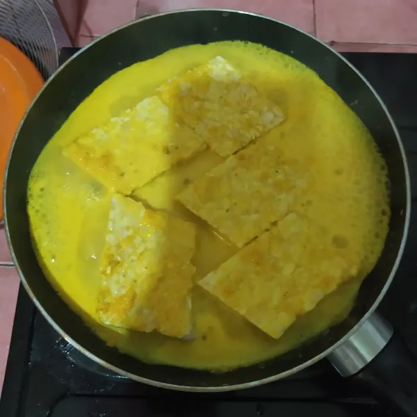 Tuang ke wajan dan beri susu, aduk rata.
Masukkan tempe garit.