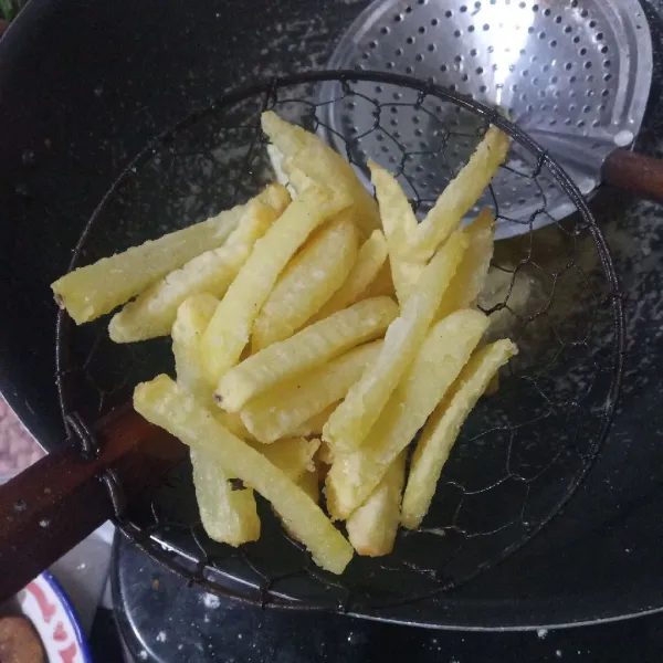 Panaskan minyak di wajan, lalu masukkan kentang. Goreng setengah matang, lalu dinginkan. Kemudian goreng kembali hingga garing, lalu angkat dan tiriskan.