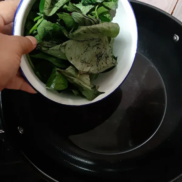 Didihkan air, kemudian masukkan daun ubi. Rebus hingga daun ubi cukup lunak, lalu angkat dan tiriskan.