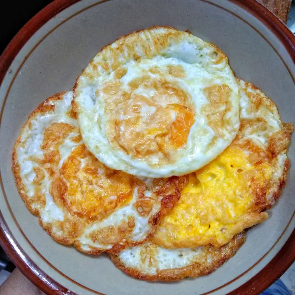 Goreng telur menjadi telur ceplok / telur mata sapi, sisihkan.