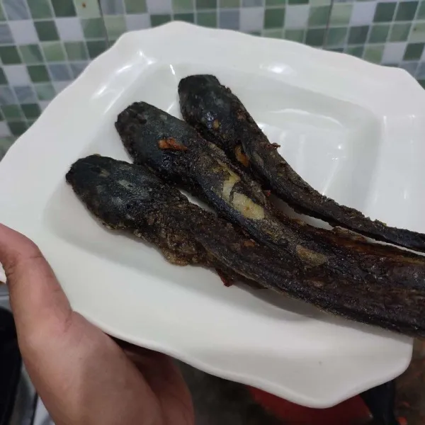 Tata ikan lele goreng di atas piring saji.