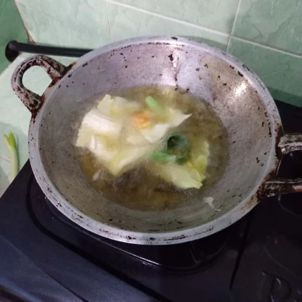 Goreng tempura sayuran dengan minyak panas hingga matang.