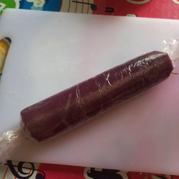 Biarkan hangat, lalu keluarkan dari cetakan, letakkan di atas plastik lebar. Kemudian gulung sambil ditekan dan bagian ujung gulungan diikat. Diamkan di kulkas minimal 30 menit. Ini saya semalaman ya.