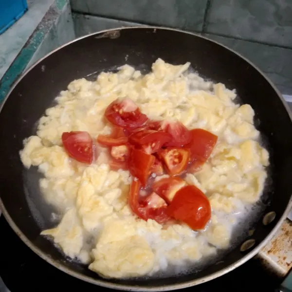 Tambahkan air dan potongan tomat.