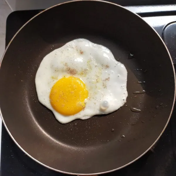 Pecahkan telur dan taburi dengan merica bubuk, masak sampai bagian putih matang atau kuning telur 1/2 matang.