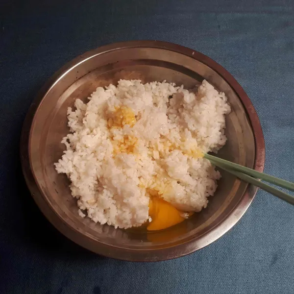 Dalam wadah campurkan telur, penyedap rasa, gula ke nasi, aduk hingga semua permukaan nasi tertutup.