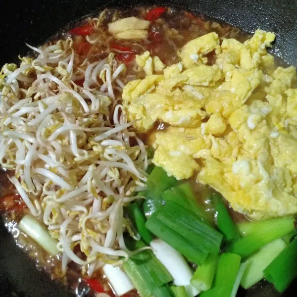 Masukkan tauge, telur goreng, potongan daun bawang dan jahe. Aduk dan masak hingga air menyusut.