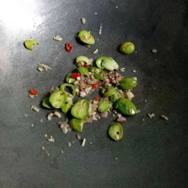Masukkan petai dan tumis hingga setengah layu.