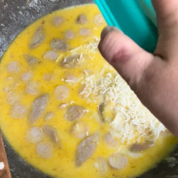 Masukkan keju parut dan garam.