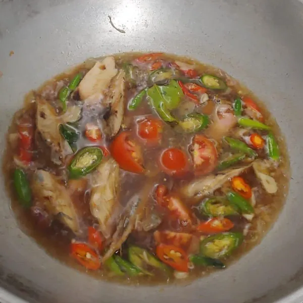 Masak tongkol sampai air agak menyusut, lalu cicipi rasanya. Kalau rasa sudah pas masukkan potongan tomat dan cabai rawit utuh, kemudian aduk-aduk sebentar dan matikan kompor.