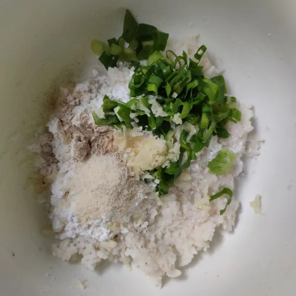 Masukkan tepung tapioka, daun bawang, bawang putih, kaldu bubuk, dan lada bubuk, lalu aduk rata.