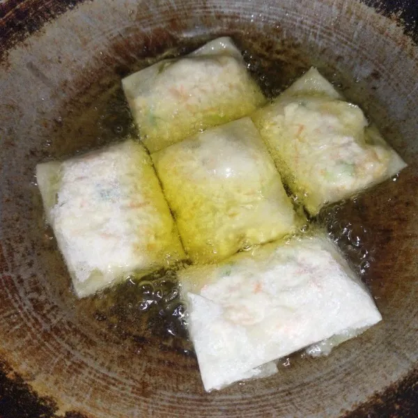 Langsung masukkan martabak tahu yang sudah dibentuk ke dalam minyak goreng yang sudah panas, lalu goreng dengan api sedang hingga matang, kemudian angkat dan sajikan.