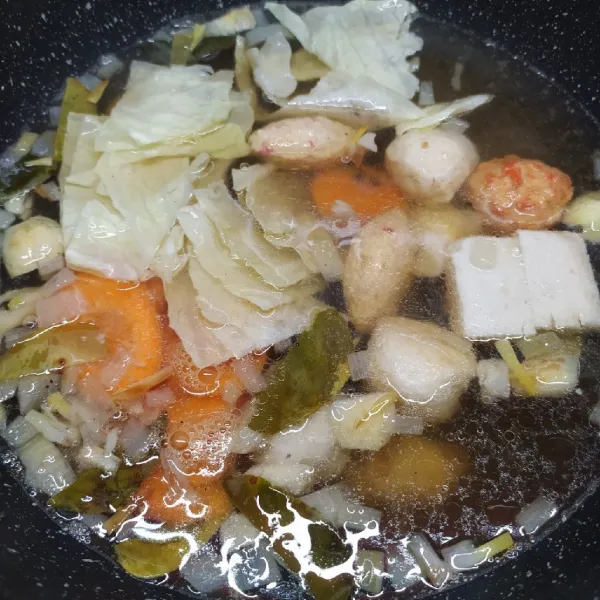 Masukkan aneka bakso ikan, kubis dan wortel. Masak sampai matang.