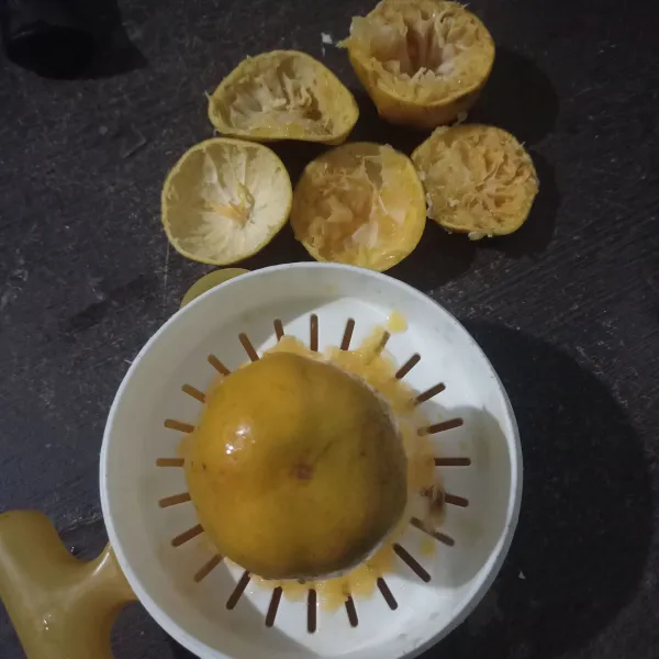 Potong buah jeruk, kemudian peras.