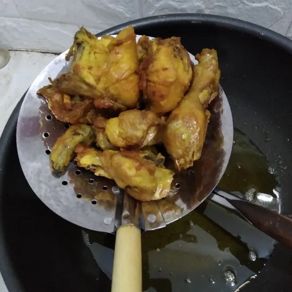 Goreng ayam dalam minyak panas hingga berwarna kuning keemasan.