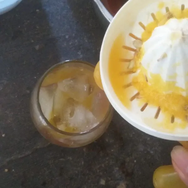 Siapkan gelas, lalu masukkan es batu dan air perasan jeruk manis.