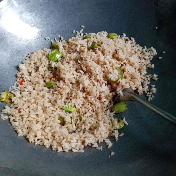 Masukkan nasi, lalu bumbui dengan garam, terasi, gula, dan lada bubuk. Masak hingga matang.