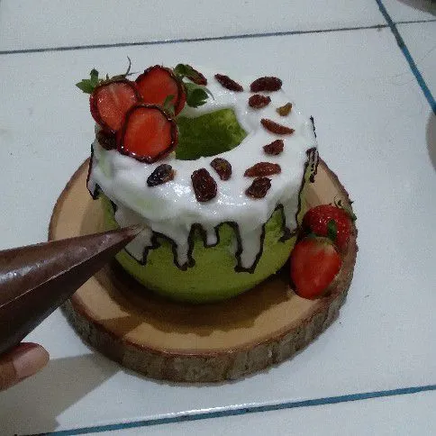 Kemudian semprotkan fla santan di atas roti dan tambahkan topping buah. Lalu bagian pinggiran lukis dengan selai cokelat.