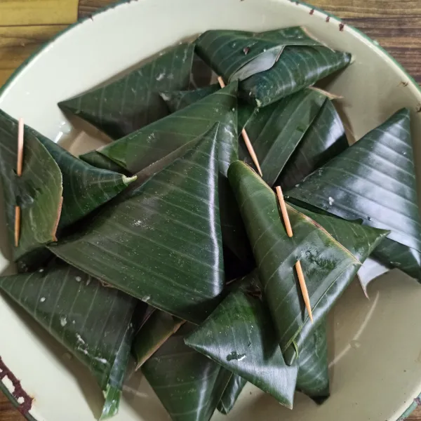 Bungkus singkong dengan daun pisang bentuk segitiga.