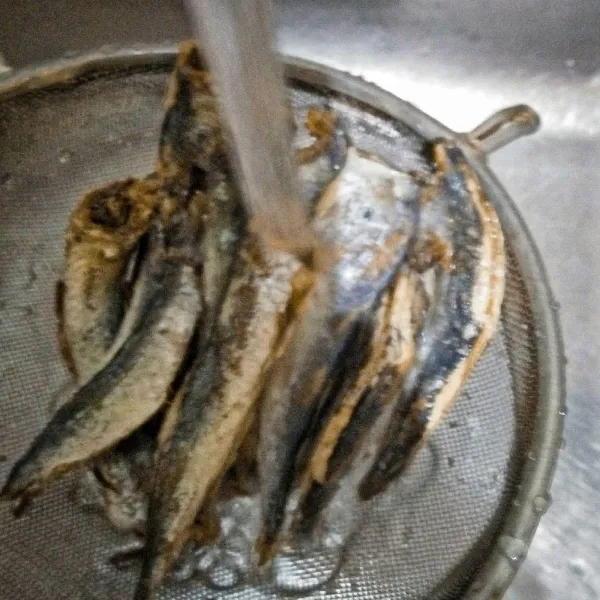 Cuci bersih ikan asin layang.
