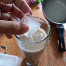 Tuang susu ke gelas, tambahkan air teh dan masukkan es batu, siap disajikan.