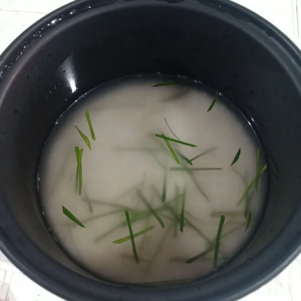 Masak nasi, air, dan irisan daun jeruk dalam magicom sampai matang.