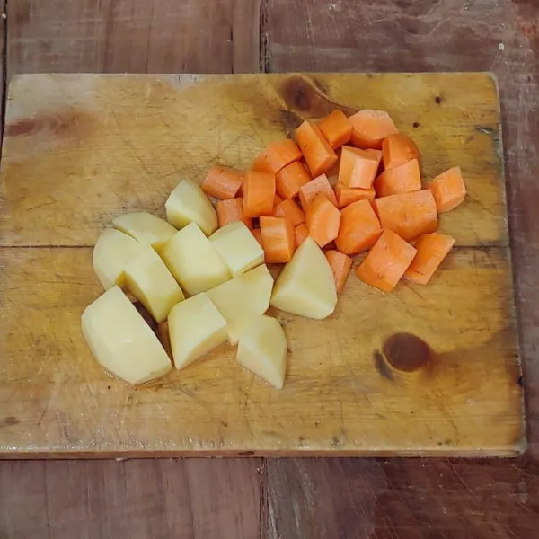 Wortel dan kentang dikupas lalu dipotong-potong seperti dadu.