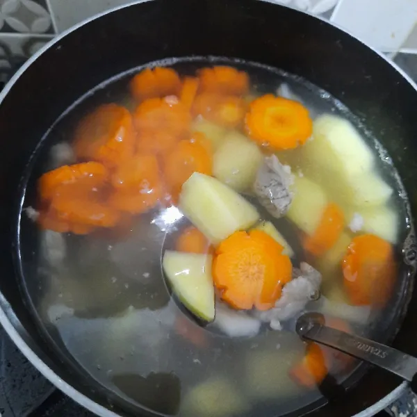 Masukkan kentang dan wortel ke dalam rebusan daging. Lalu masukkan tumis bawang putih ke dalam sup. Aduk rata, masak sampai mendidih.