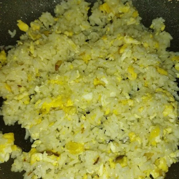 Aduk nasi hingga semua bahan tercampur rata, lalu cicipi rasanya dan masak hingga nasi agak kering. Kemudian angkat dan sajikan.