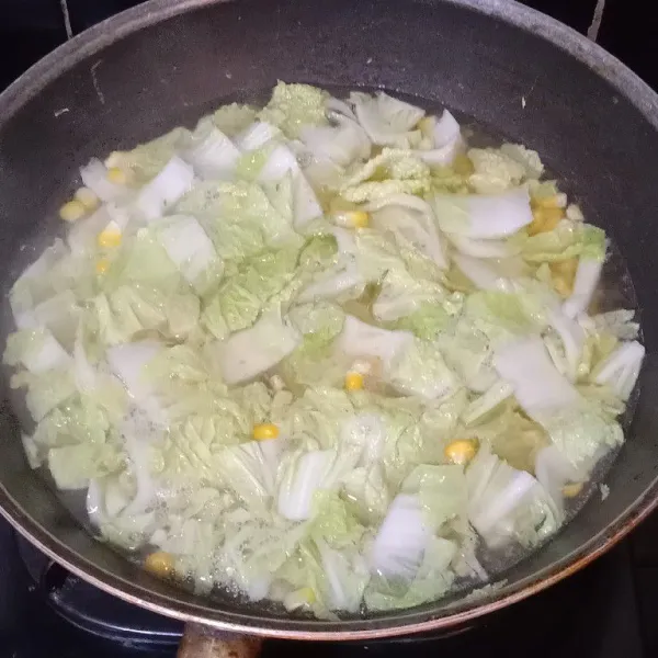 Tumis bawang putih lalu tambahkan petcai dan jagung manis, beri air dan tunggu hingga sayur lunak.