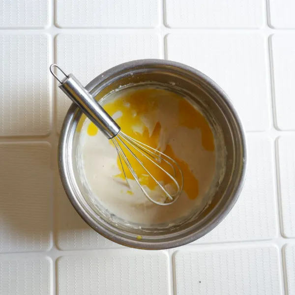 Tambahkan kocokan telur tadi kemudian aduk rata dan beri air lalu tambahkan margarin cair.