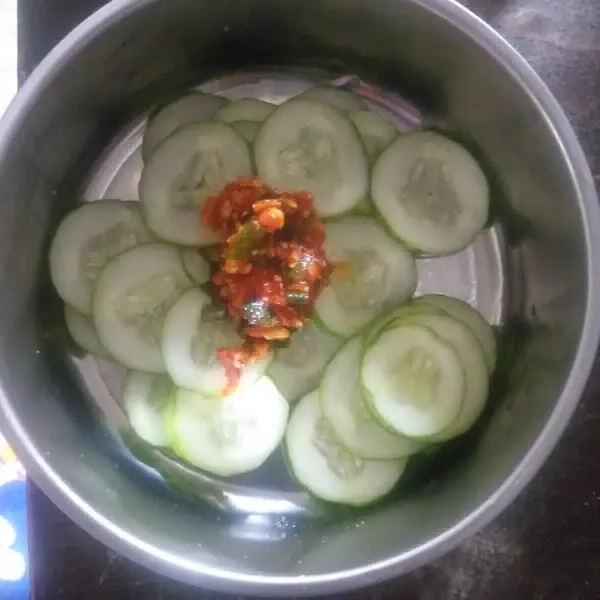 Dalam wadah masukkan irisan timun, masukkan saus sambal dan aduk rata. Taburi dengan wijen sangrai dan simpan dalam kulkas. Lalu nikmati saat dingin.