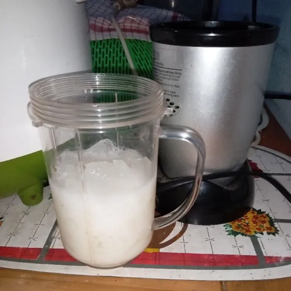 Masukkan susu cair dan es batu ke dalam gelas blender.