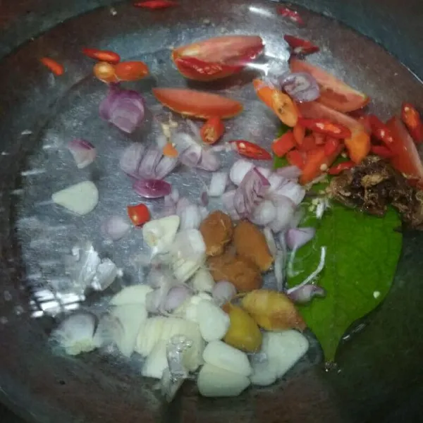 Dalam panci tuang air, bumbu iris, daun salam, lengkuas, asam Jawa, didihkan air.