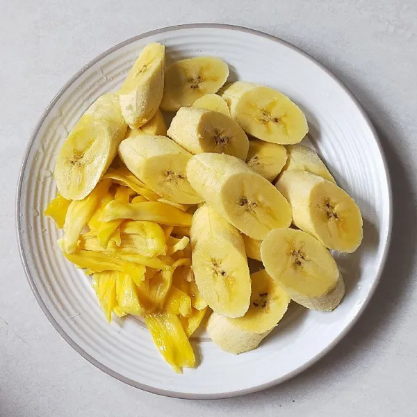 Siapkan daging buah nangka, lalu suwir-suwir dan siapkan juga pisang yang sudah di potong serong. Kemudian sisihkan.