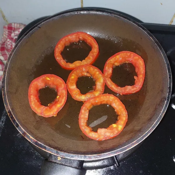 Letakkan tomat di pan datar yang sudah diberi sedikit minyak.