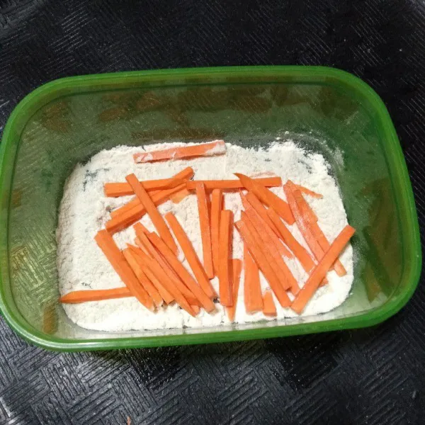 Siapkan tepung, lalu masukkan ubi yang sudah di rendam lalu balur ke semua permukaan ubi hingga tertutup tepung.