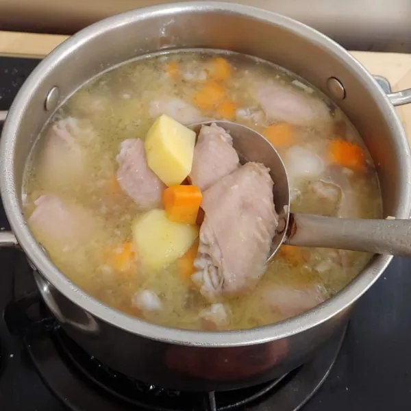 Masukkan kentang dan wortel, masak sampai sayap empuk, wortel dan kentang matang.