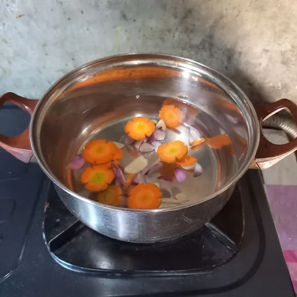 Didihkan air. Masukkan irisan bawang dan wortel. Masak sampai wortel setengah empuk.