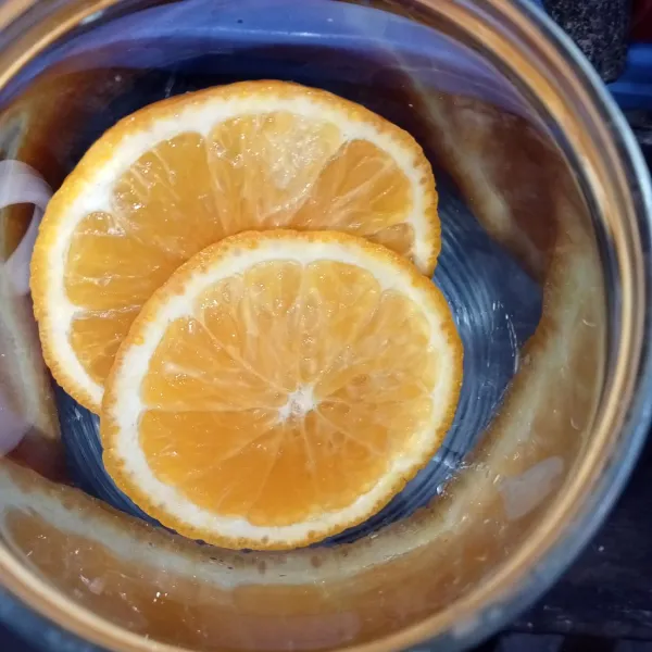 Masukkan es batu dan irisan jeruk kedalam gelas