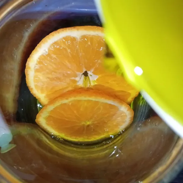 Tuang sirup jeruk kedalam gelas