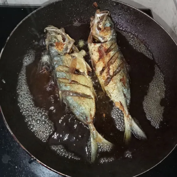 Panaskan minyak kemudian masukkan ikan kembung lalu goreng hingga kuning kecoklatan dan tiriskan, ikan kembung kunyit bawang putih siap dinikmati.