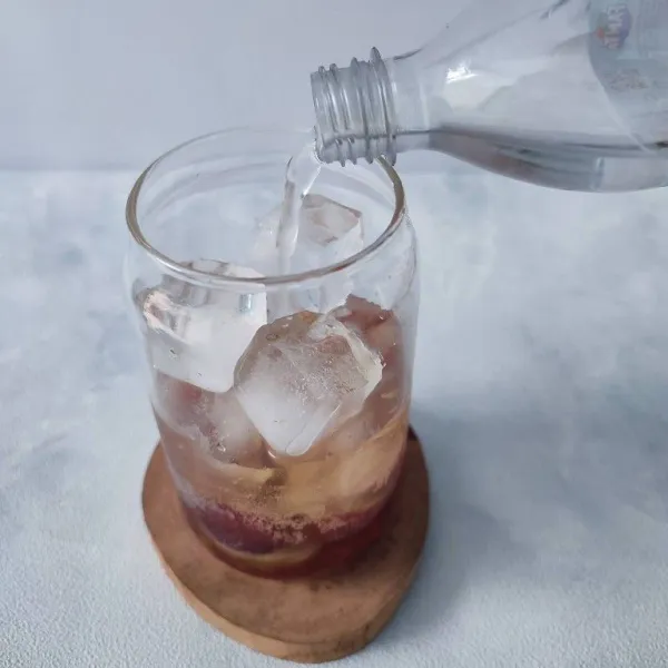 Tuang air soda tawar sampai gelas penuh. Aduk rata, sajikan selagi dingin.