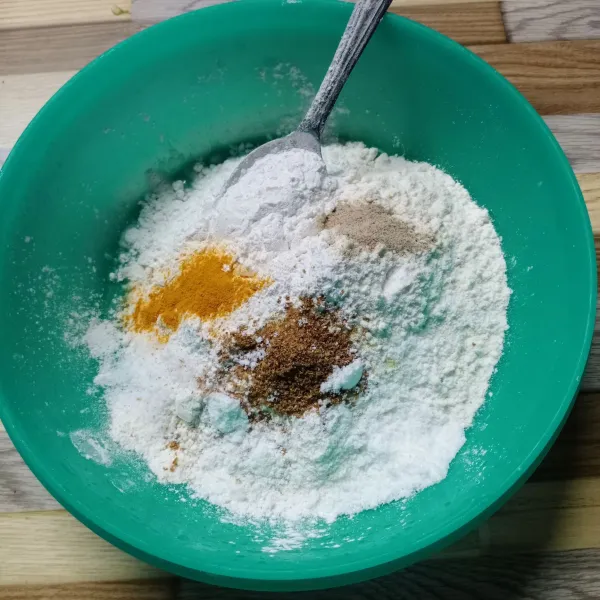 Dalam wadah masukkan tepung terigu, tepung beras, garam, kaldu bubuk, ketumbar bubuk, bawang putih bubuk, lada bubuk dan kunyit bubuk.
