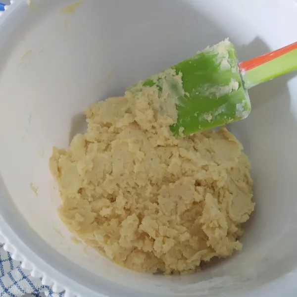 Masukkan juga secara bertahap campuran tepung, maizena, dan susu bubuk, aduk rata menggunakan spatula.