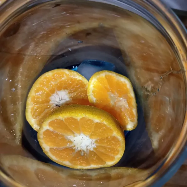 Masukkan potongan jeruk kedalam gelas.