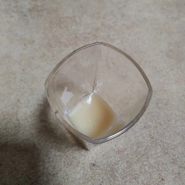 Tuang krimer kental manis di dasar gelas.