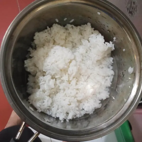 Campur nasi dan garam di panci.
