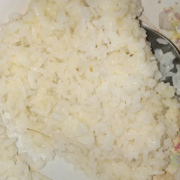 Siapkan wadah, campur jadi satu nasi, 3 sdm telur kocok, garam dan air, aduk rata.