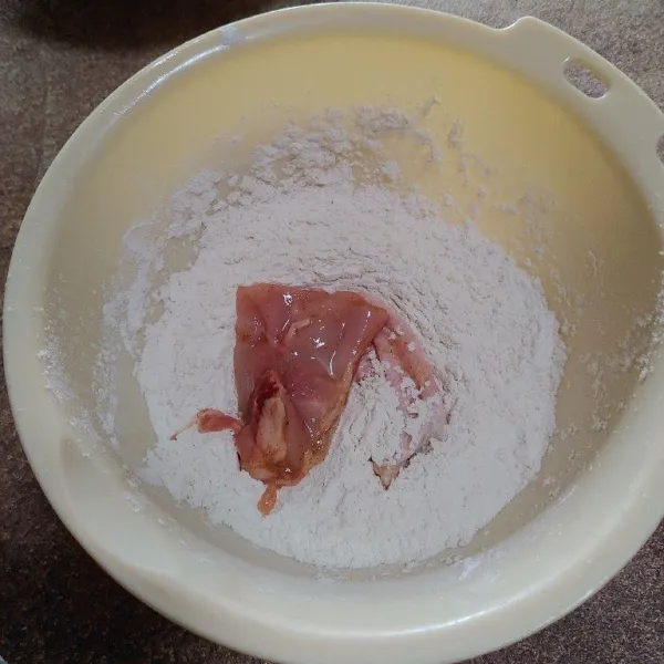 Setelah 1 jam marinasi, masukkan potongan ayam ke dalam tepung kering yang sudah dibumbui.